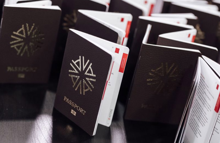 A wooden office table with several passport style booklets standing upright on it