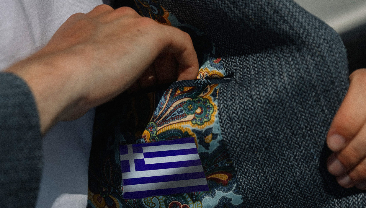 an expensive grey suit with the flag of Greece stitched to the inside of the jacket
