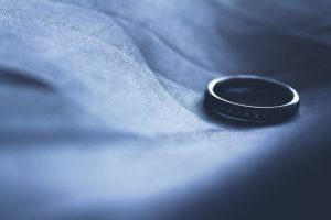 a wedding ring on bed sheet